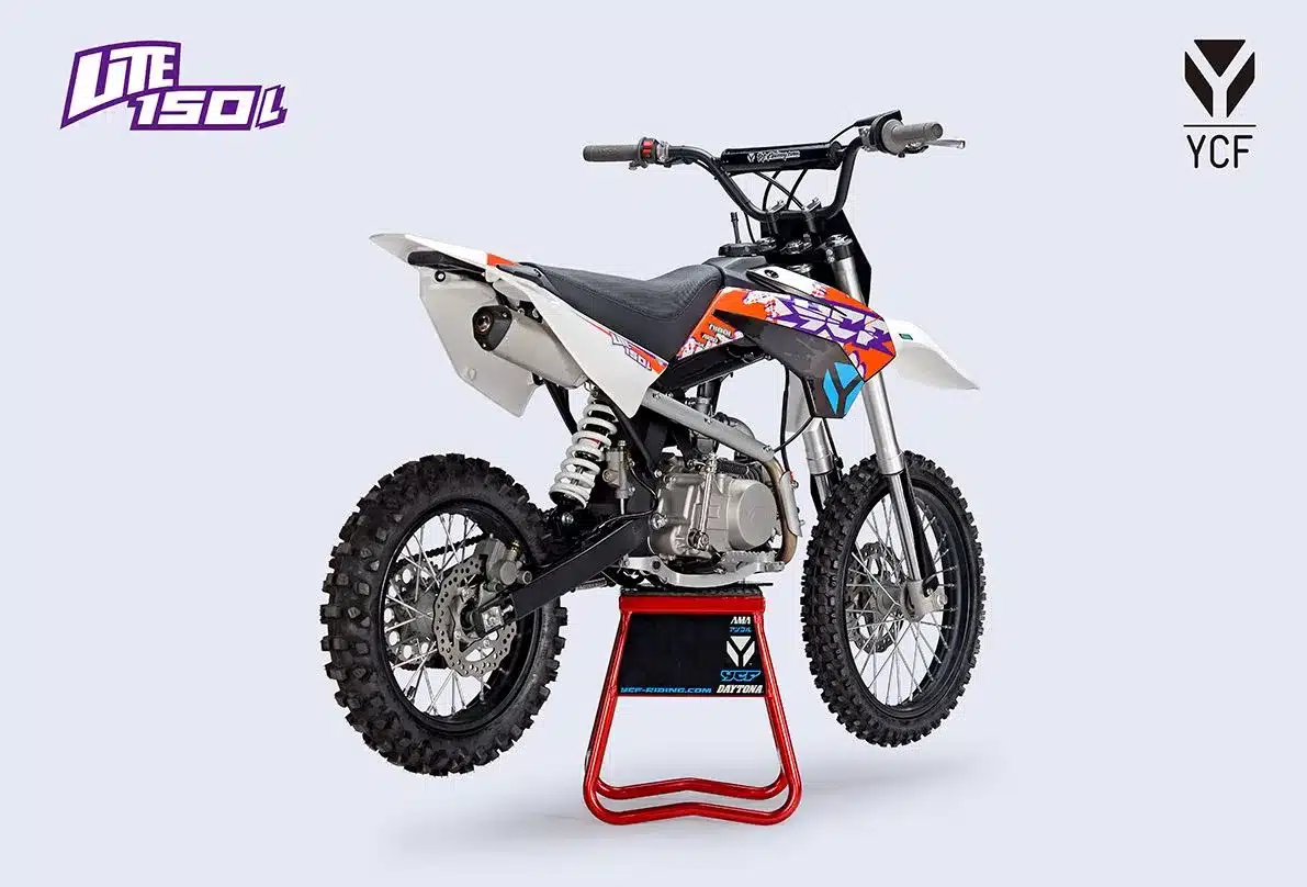 YCF Lite 150 L 2026 Pit Bike auf Ständer, von schräg hinten fotografiert, mit Offroad-Profil und bunter Verkleidung.