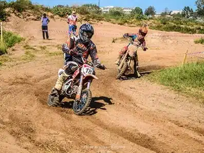 Kinder fahren mit Apollo RXF Junior 110 Motocross-Bikes auf einer Offroad-Strecke.
