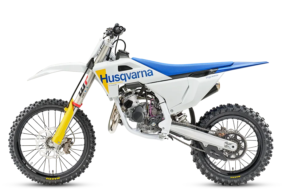 Seitenansicht der Husqvarna TC 85 17/14 Motocross-Maschine mit weiß-gelbem Dekor und blauer Sitzbank