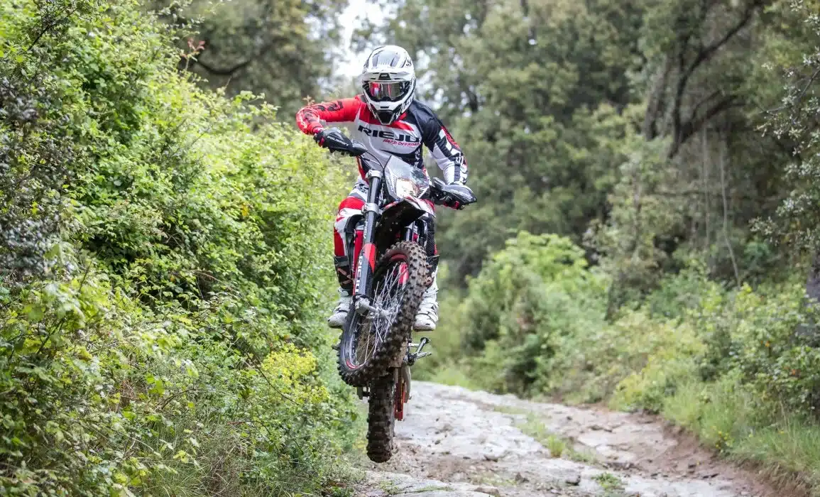 Fahrer auf einer Rieju MR PRO 125 beim Offroad-Einsatz auf einem steinigen Waldweg
