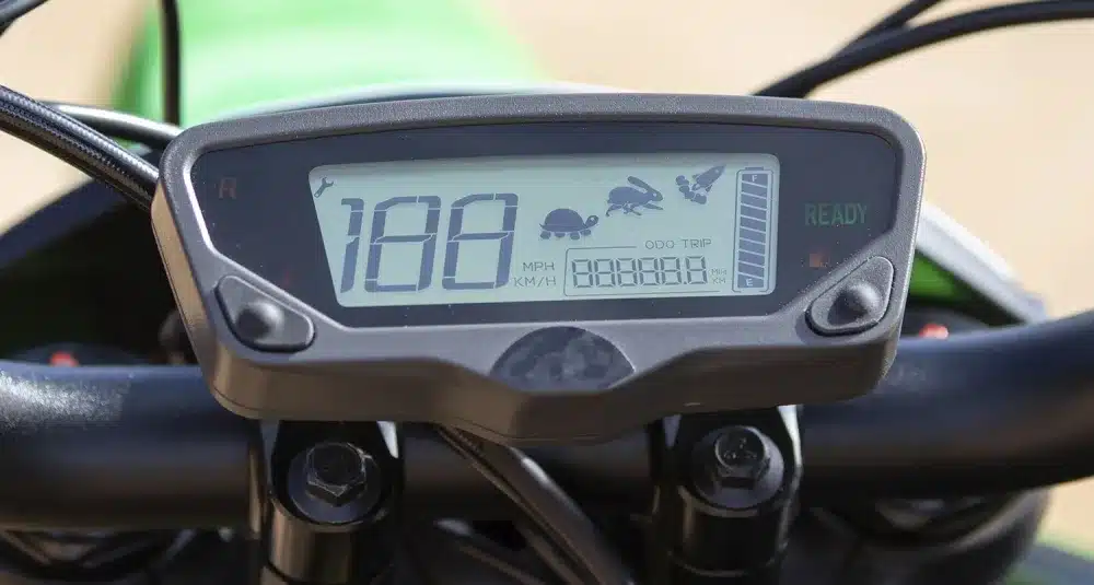 Nahaufnahme des digitalen Cockpits der Rieju e-Tango mit Symbolen für drei Fahrmodi, Geschwindigkeits- und Akkustandsanzeige.