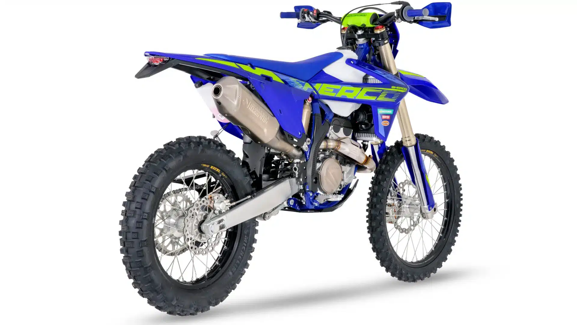 Sherco 300 SEF Factory 2026 von schräg hinten, blaues Bodykit, Akrapovič-Endschalldämpfer und Michelin Enduro Medium Reifen.