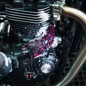 Detailaufnahme: Mikrofaser-Bürste säubert einen Motorrad-Motor