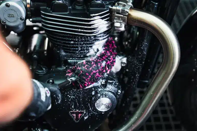Detailaufnahme: Mikrofaser-Bürste säubert einen Motorrad-Motor