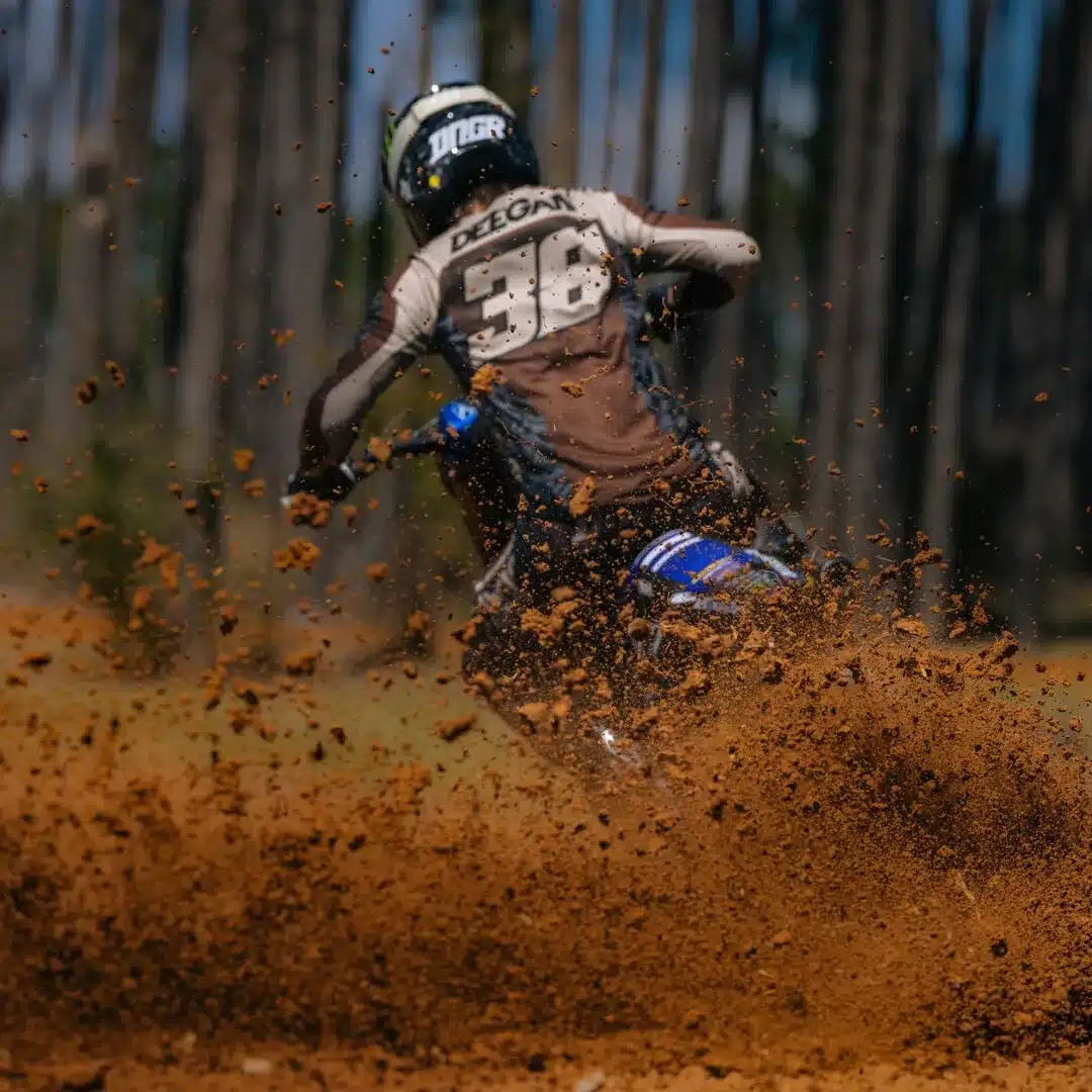 Motocross-Fahrer mit Flexair HD38 Trikot und Helm von Haiden Deegan, wirbelt Sand auf der Strecke auf.
