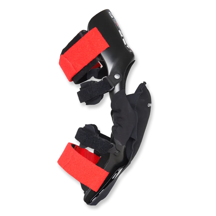 Seitliche Ansicht der X-PERT Knee Brace Adventure Knieorthese mit roten Riemen, speziell für Motorradfahrer entwickelt.