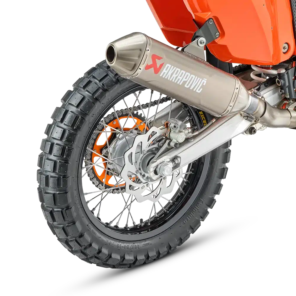Detailansicht vom Hinterrad und Auspuff der KTM 450 RALLY REPLICA 2027 mit Akrapovič-Schalldämpfer.