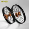 Zwei komplette Offroad-Laufräder mit schwarzen Felgen, CNC-gefrästen orange Aluminium-Naben und Edelstahlspeichen, geeignet für KTM SX-F und EXC Modelle