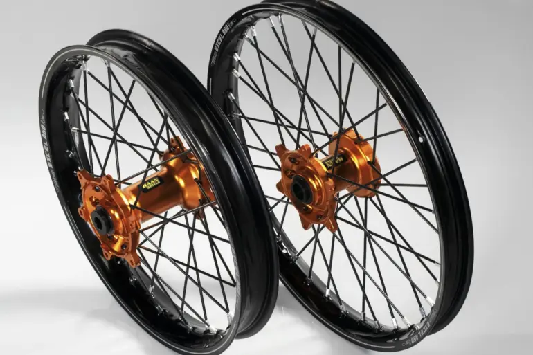 Zwei komplette Offroad-Laufräder mit schwarzen Felgen, CNC-gefrästen orange Aluminium-Naben und Edelstahlspeichen, geeignet für KTM SX-F und EXC Modelle