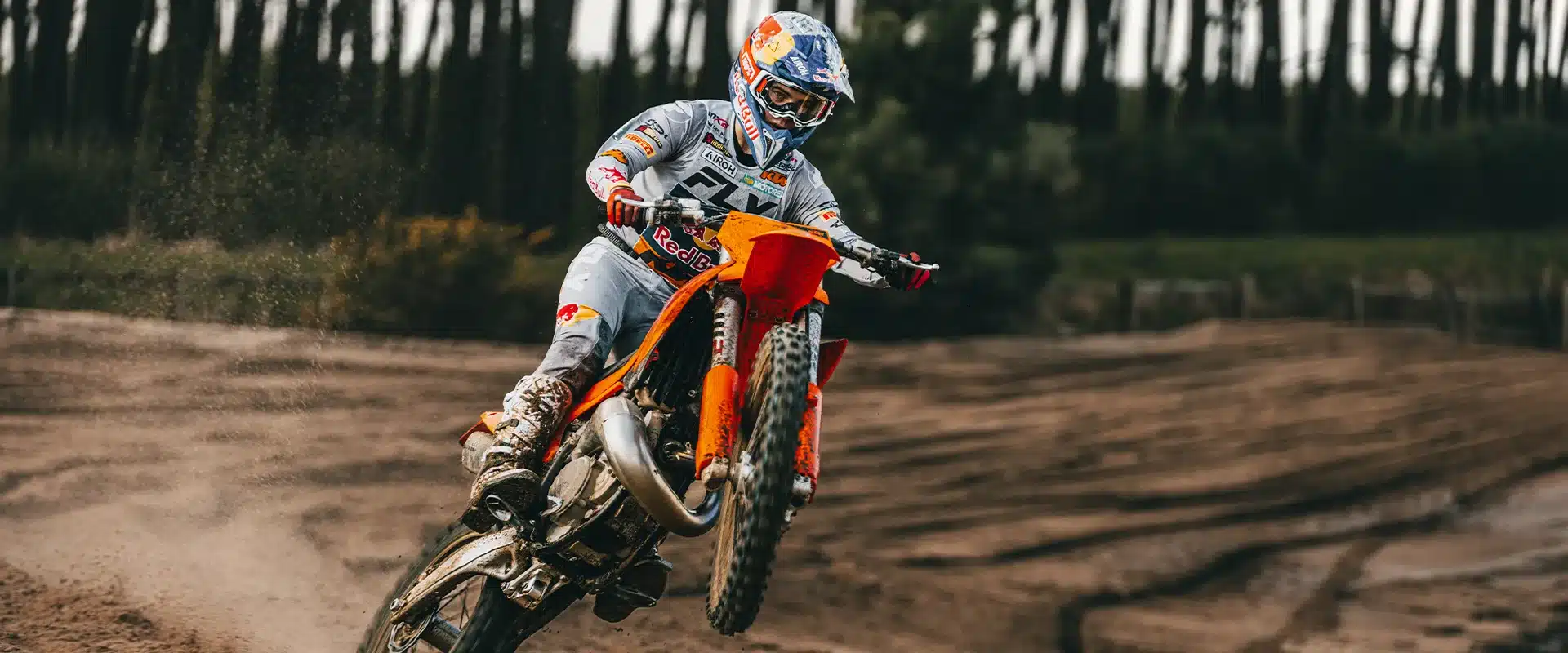 Motocross-Fahrer fährt die orange 2027 KTM 125 SX sportlich über eine sandige Piste