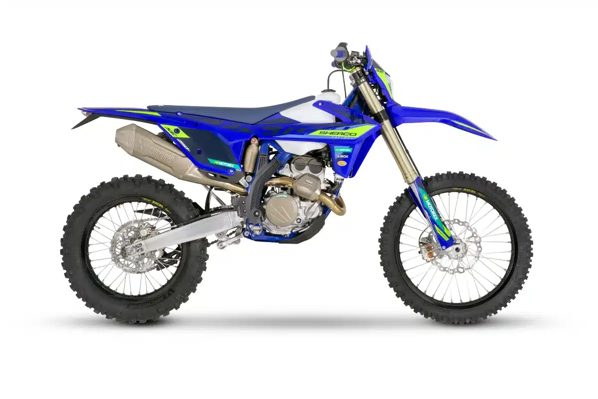 Sherco 250 SEF FACTORY 2027 Enduro-Motorrad in Seitenansicht, blau-gelb, mit Akrapovič-Abgasanlage und modernen Komponenten.