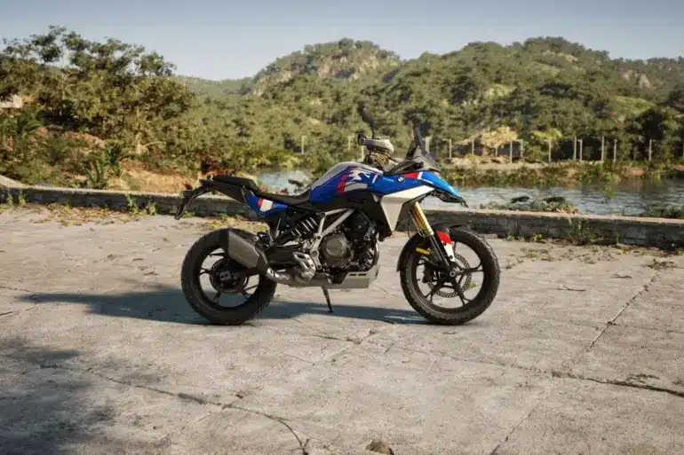 BMW F 450 GS Motorrad in blau, seitlich fotografiert, im Außenbereich mit Bergen und See im Hintergrund