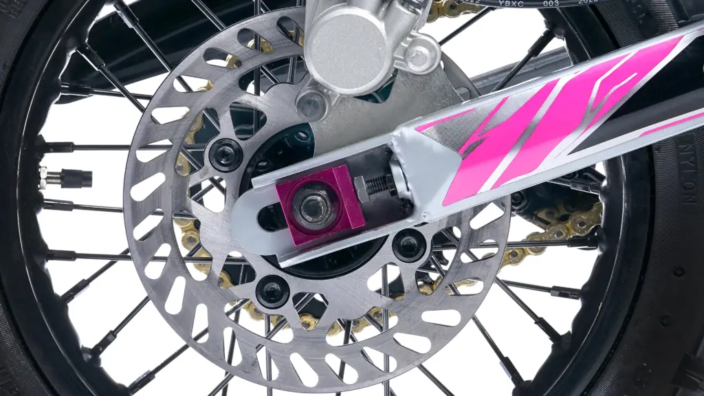 Nahaufnahme der hydraulischen Scheibenbremse und Hinterradaufnahme einer Denago MX1 mit pinken Akzenten