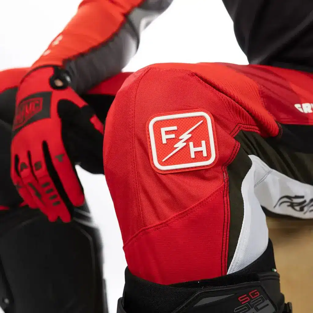 Detailaufnahme der Grindhouse Atomic Pant in Rot/Schwarz mit markanter TPR-Applikation am Knie