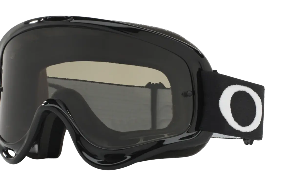 Oakley O-Frame MX Goggle in Schwarz mit dunklem Glas und breitem schwarzen Band mit weißem O-Logo, freigestellt.