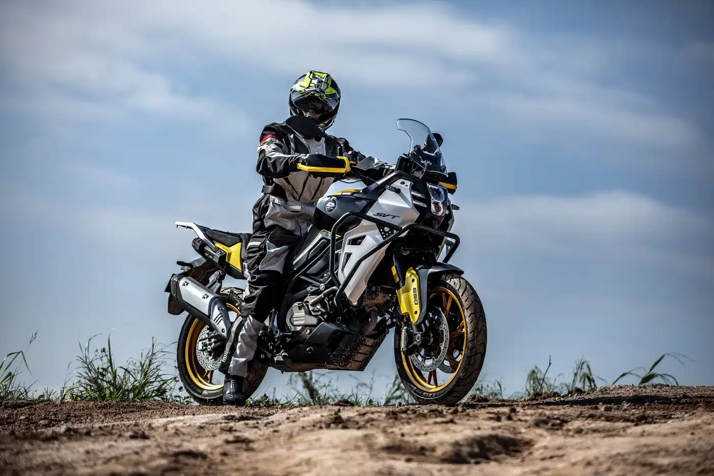 Adventure-Bike SVT 650 X wird von einem Fahrer im Gelände bewegt, seitliche Ansicht bei Tageslicht.
