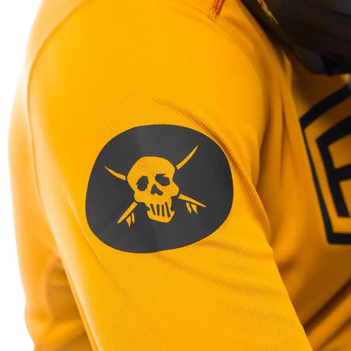 Nahaufnahme des gelben Sanguaro Bennet Jerseys mit schwarzem Totenkopf-Logo auf dem Ärmel