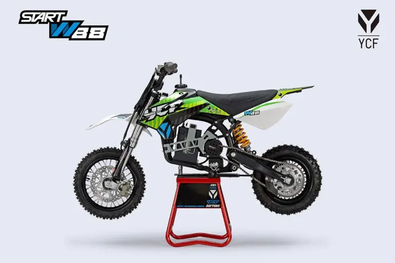 YCF START W88 E-Kindermotorrad auf einem Montageständer, seitlich fotografiert, Offroad-Bereifung und sportliches Design.