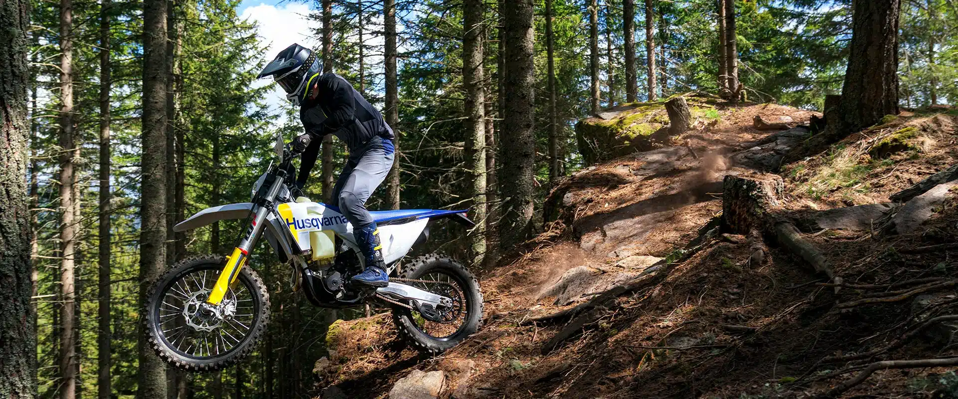 Fahrer mit Husqvarna FE 350 fährt durch anspruchsvolles Waldgelände.