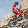 Beta RR X-PRO 4T 350 Enduro-Motorrad fährt einen steinigen Hang hinauf, Fahrer in roter Schutzkleidung.