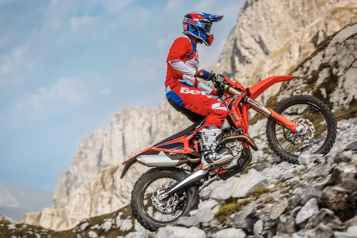 Beta RR X-PRO 4T 350 Enduro-Motorrad fährt einen steinigen Hang hinauf, Fahrer in roter Schutzkleidung.