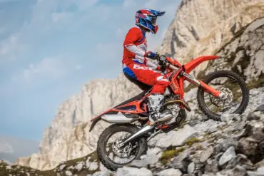 Beta RR X-PRO 4T 350 Enduro-Motorrad fährt einen steinigen Hang hinauf, Fahrer in roter Schutzkleidung.