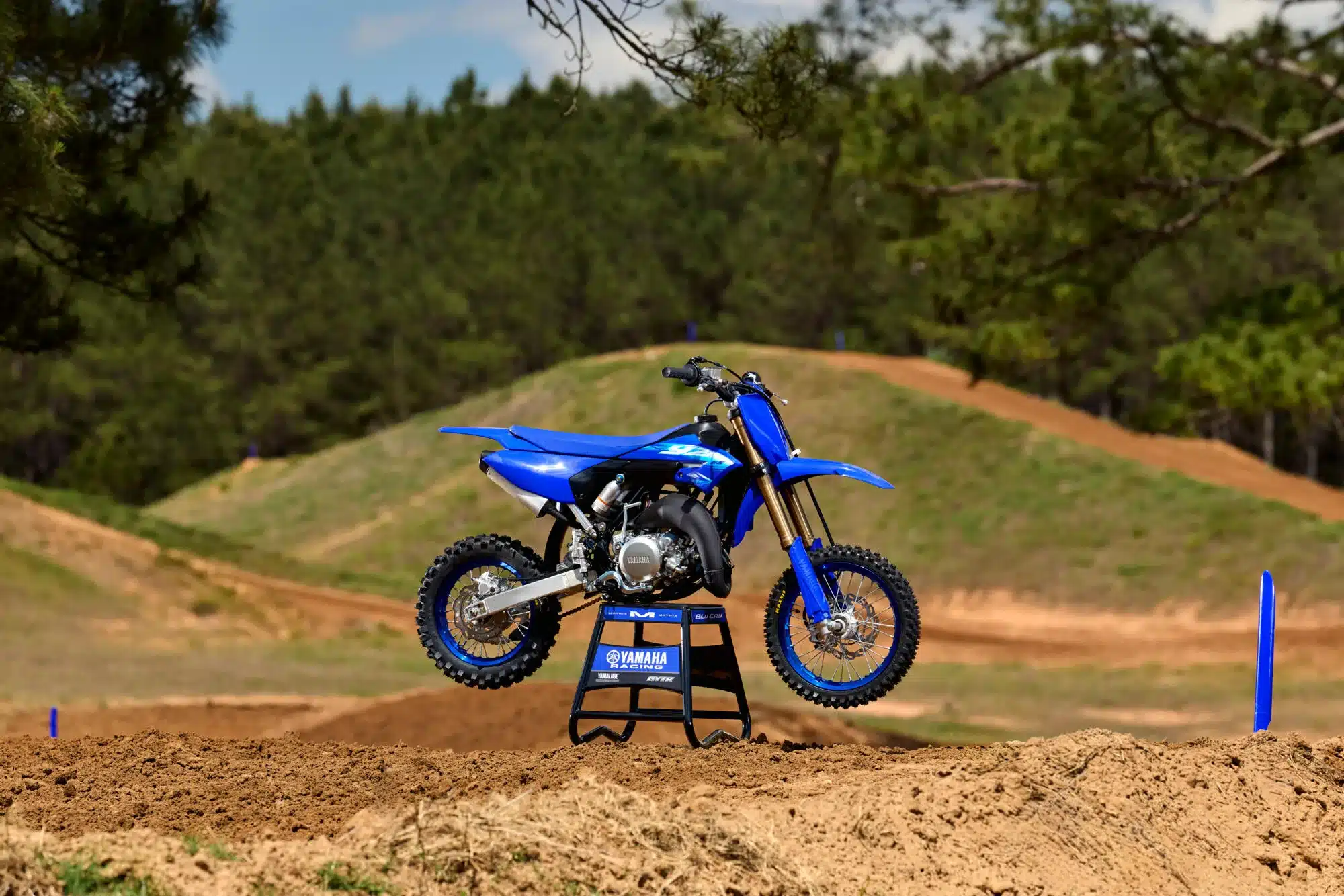 Yamaha YZ65 in Icon Blue auf einer Motocross-Strecke vor grünem Hintergrund