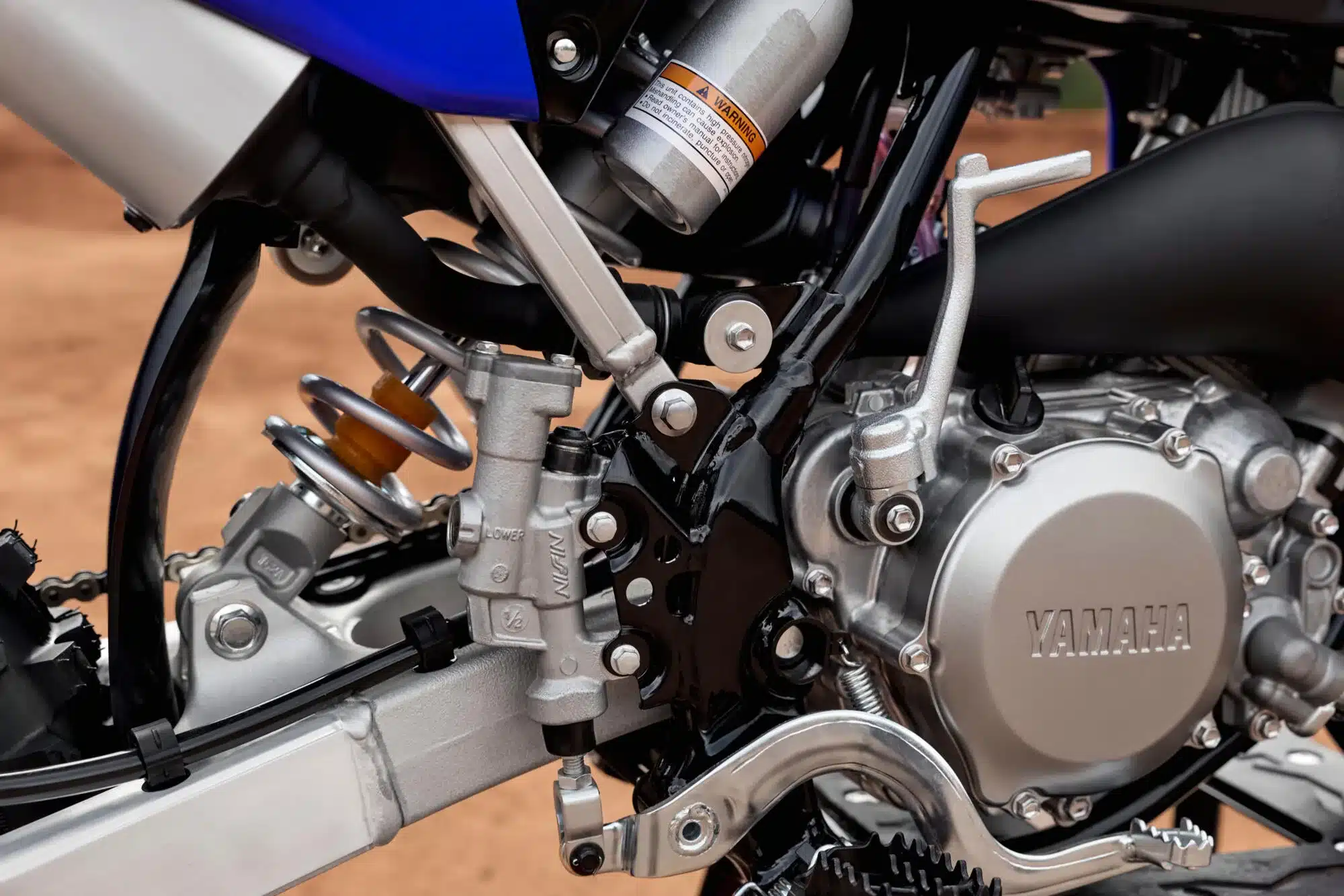 Detailaufnahme des Motors und Fahrwerks der Yamaha YZ65, hervorgehoben sind Federung, Kicker und Motorgehäuse
