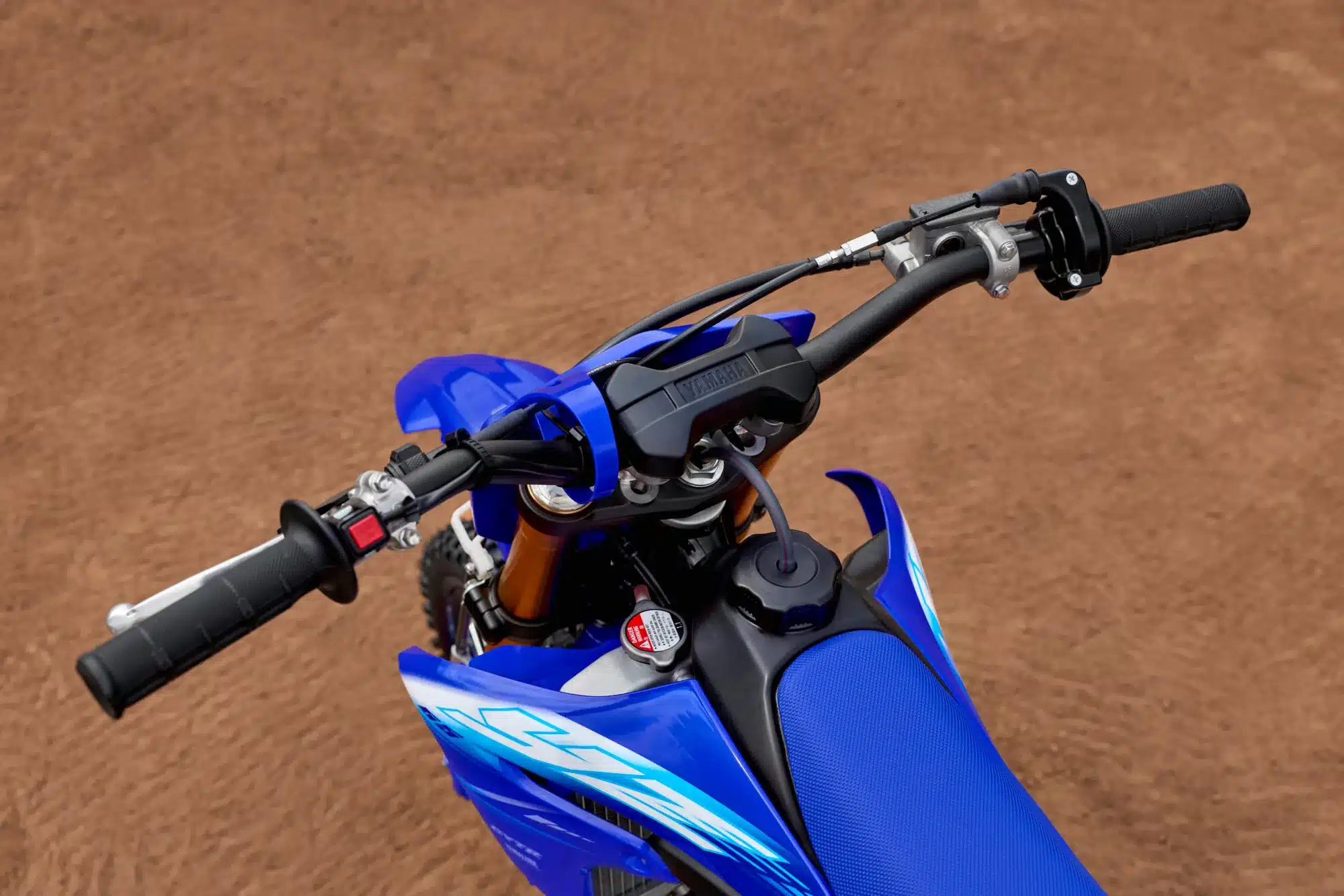 Nahaufnahme des Lenkers einer Yamaha YZ65 in Icon Blue auf sandigem Untergrund.