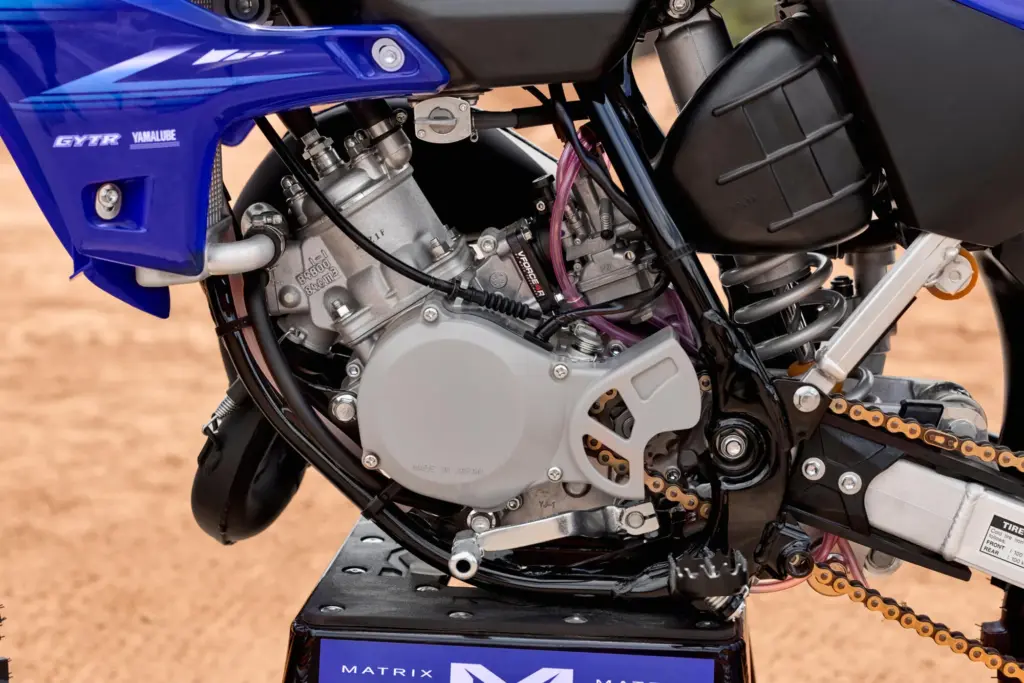 Nahaufnahme des Motors der Yamaha YZ85 mit sichtbarem YPVS-System und Vergaser