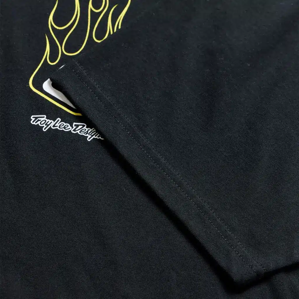 Schwarzes Kurzarmshirt mit gelbem Flame2-Motiv und sichtbarer Ärmelnaht