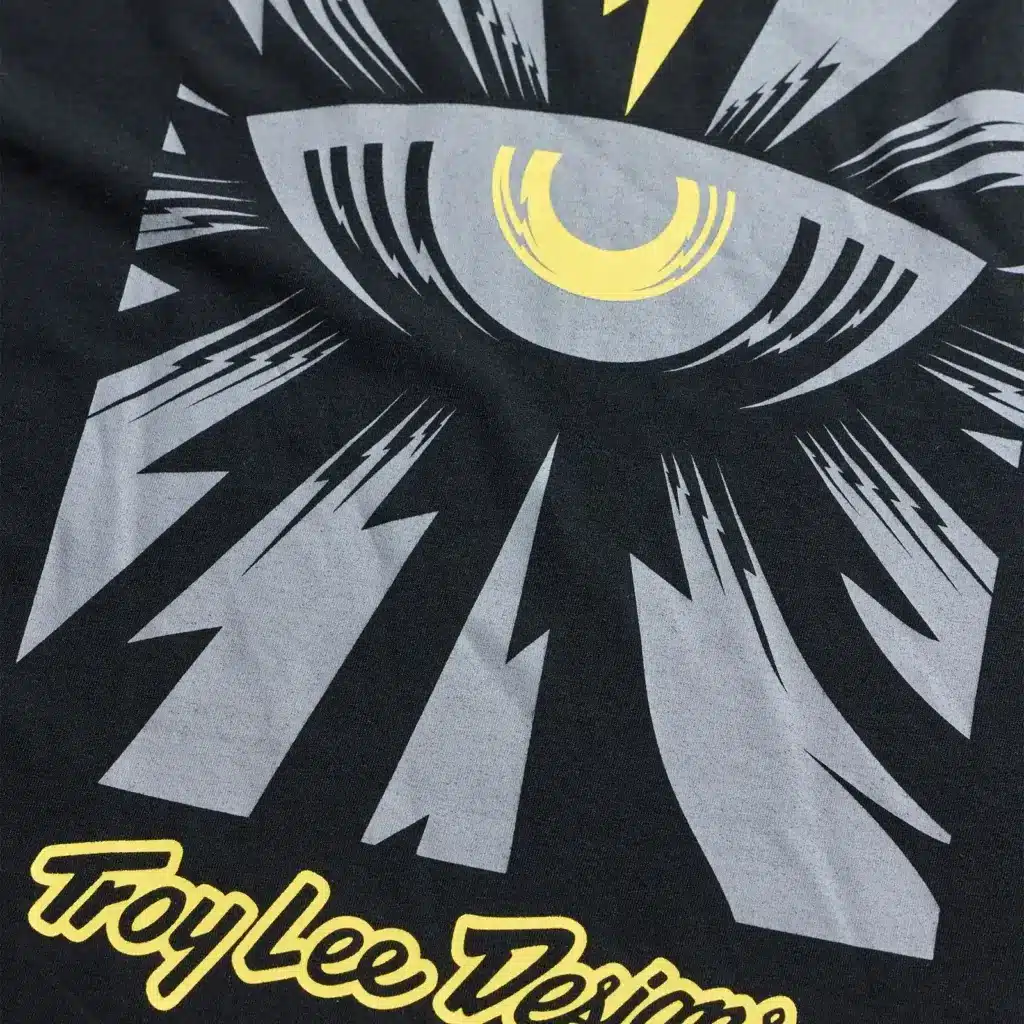 Nahaufnahme des Cyborg-Motivs auf einem schwarzen T-Shirt mit gelbem und grauem Druck von Troy Lee Designs.