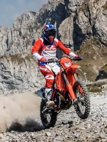 Beta RR X-PRO 4T 430 MY27 Enduro-Motorrad im Gelände, Fahrer in roter Beta-Montur, Berghintergrund.