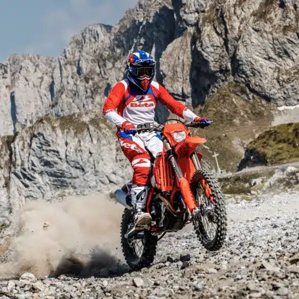Beta RR X-PRO 4T 430 MY27 Enduro-Motorrad im Gelände, Fahrer in roter Beta-Montur, Berghintergrund.