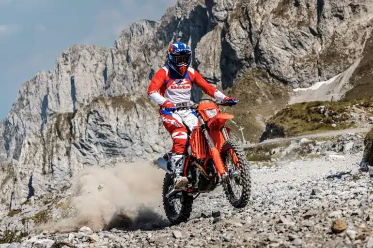 Beta RR X-PRO 4T 430 MY27 Enduro-Motorrad im Gelände, Fahrer in roter Beta-Montur, Berghintergrund.