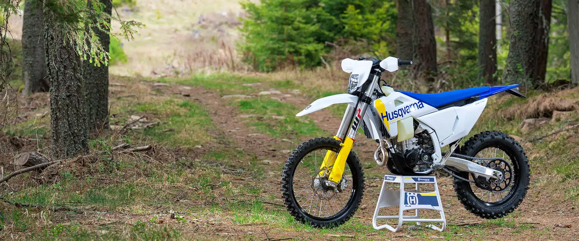 Husqvarna FE 450 Enduro 2027 auf Waldweg, seitliche Ansicht