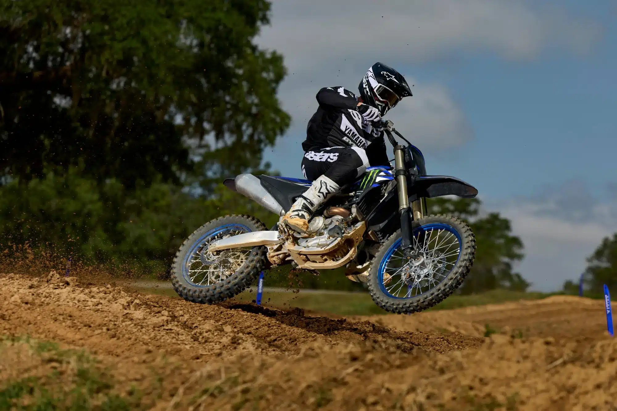 Motocross-Fahrer auf Yamaha YZ450F Monster Energy Yamaha Racing Edition springt über sandigen Untergrund