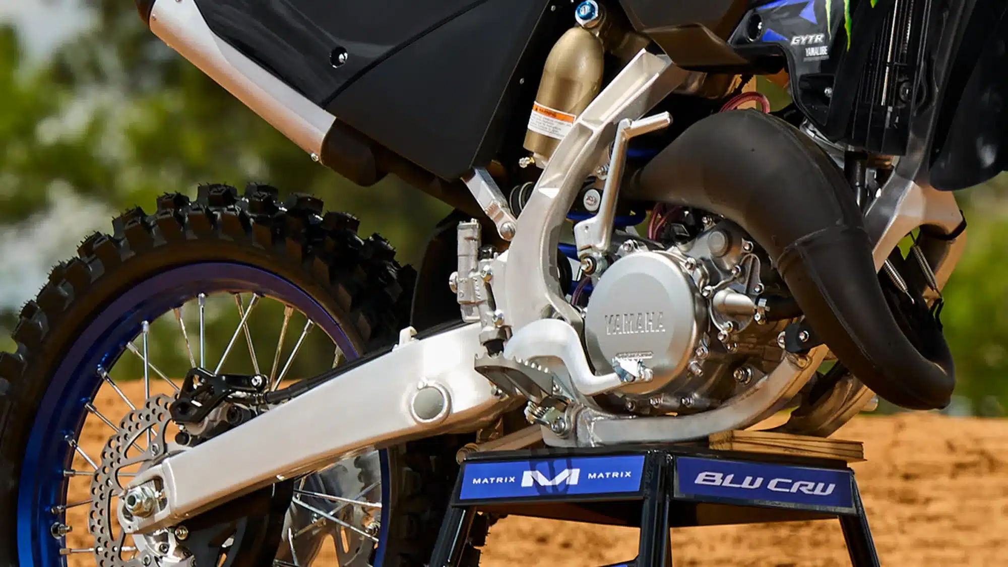 Nahaufnahme des Antriebsstrangs und Fahrwerks der Yamaha YZ125 Monster Energy Racing Edition im Gelände