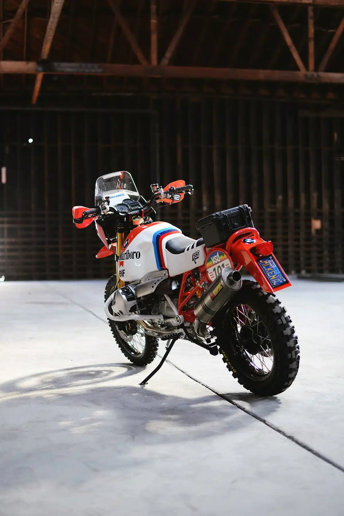 BMW RSD Dakar GS Umbau im Rallye-Stil mit Akrapovič-Anlage und Spezialausstattung, seitliche Ansicht in einer Halle.