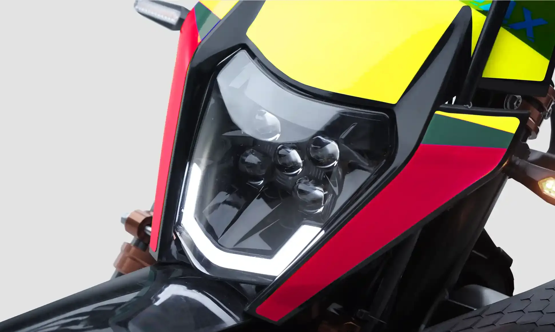 Nahaufnahme des LED-Scheinwerfers an der Kamax K20 Enduro-Motorradfront mit farbigen Verkleidungselementen.