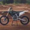 Triumph TF 450-X Motocross-Motorrad auf einer sandigen Rennstrecke im Profil