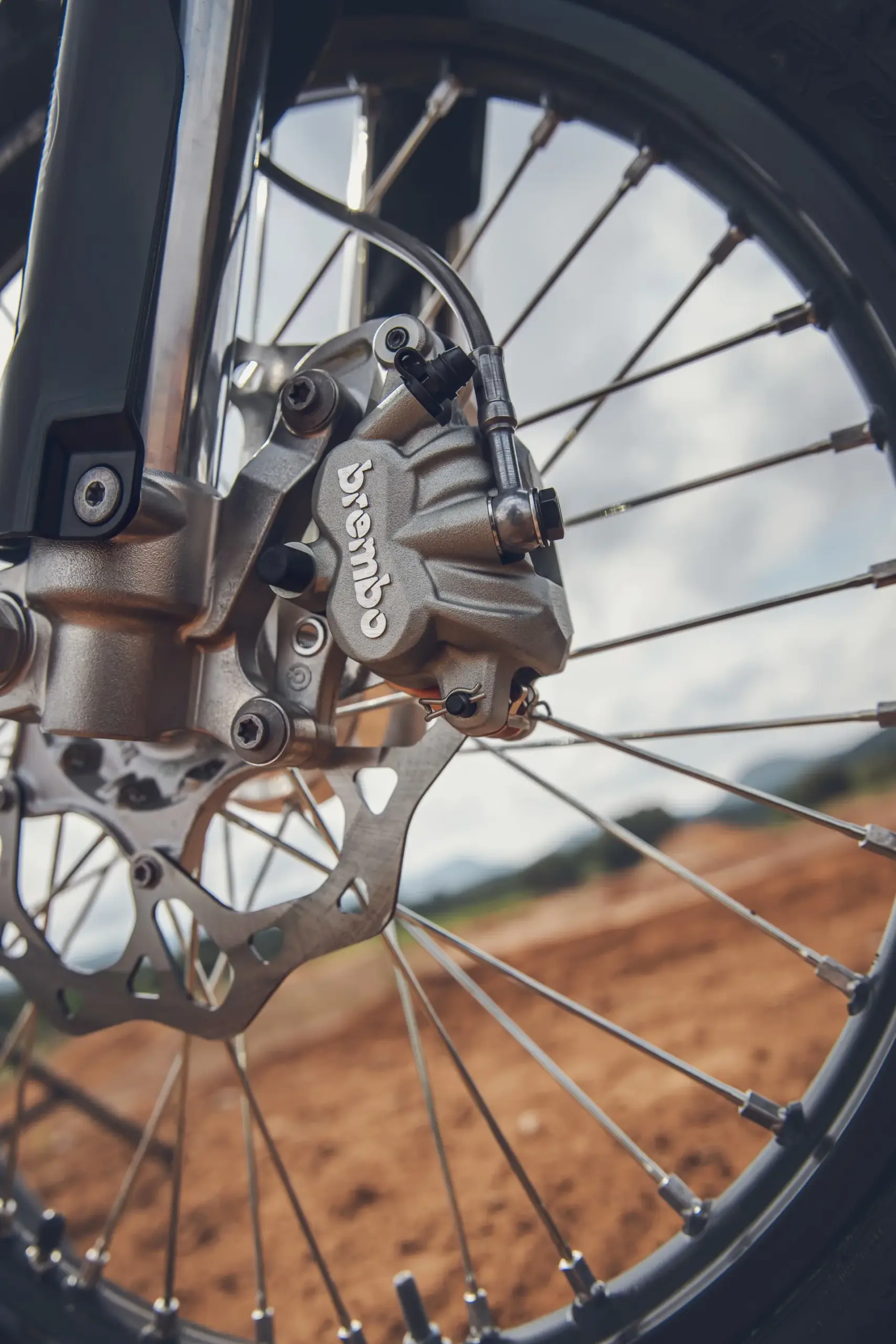 Detailaufnahme der vorderen Brembo-Bremsanlage einer Triumph TF 450-X Motocross-Maschine, Fokus auf Bremssattel und Bremsscheibe.