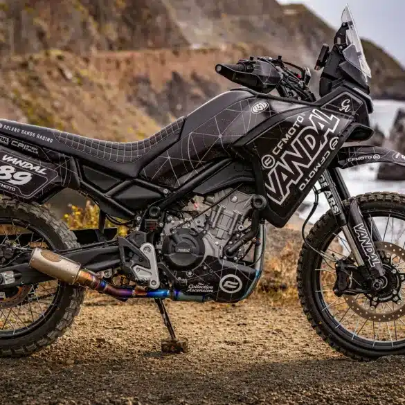 CFMOTO VANDAL 2 Adventure-Motorrad mit Offroad-Ausstattung auf Schotterpiste an der Küste