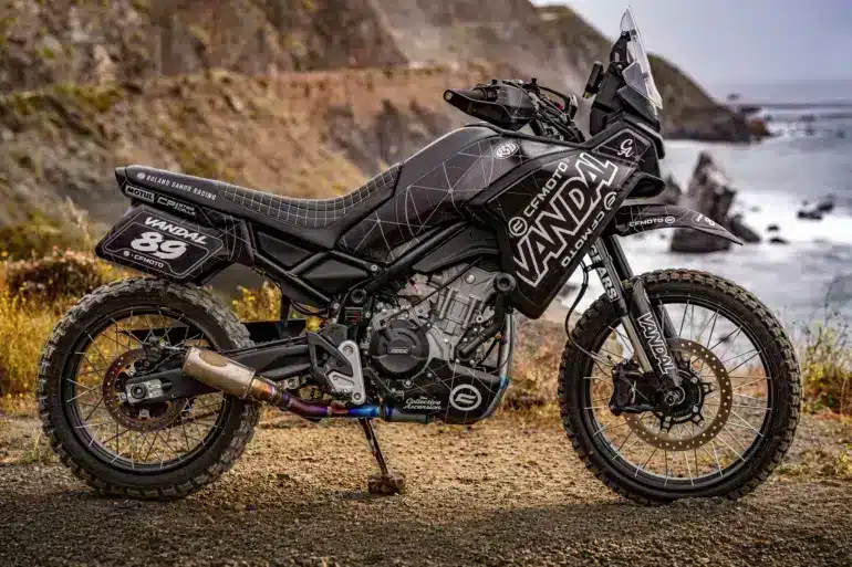 CFMOTO VANDAL 2 Adventure-Motorrad mit Offroad-Ausstattung auf Schotterpiste an der Küste