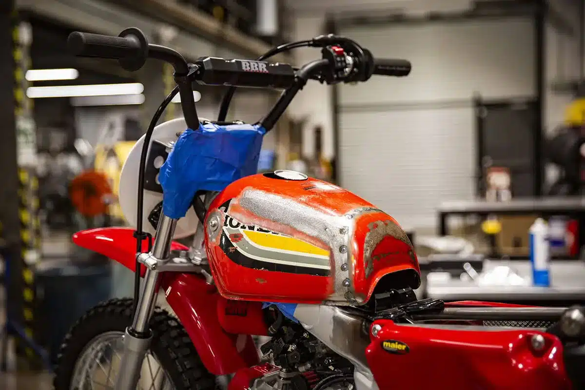 Nahaufnahme eines umgebauten Honda CRF110 Motorrads mit Retro-Tank im Baustadium