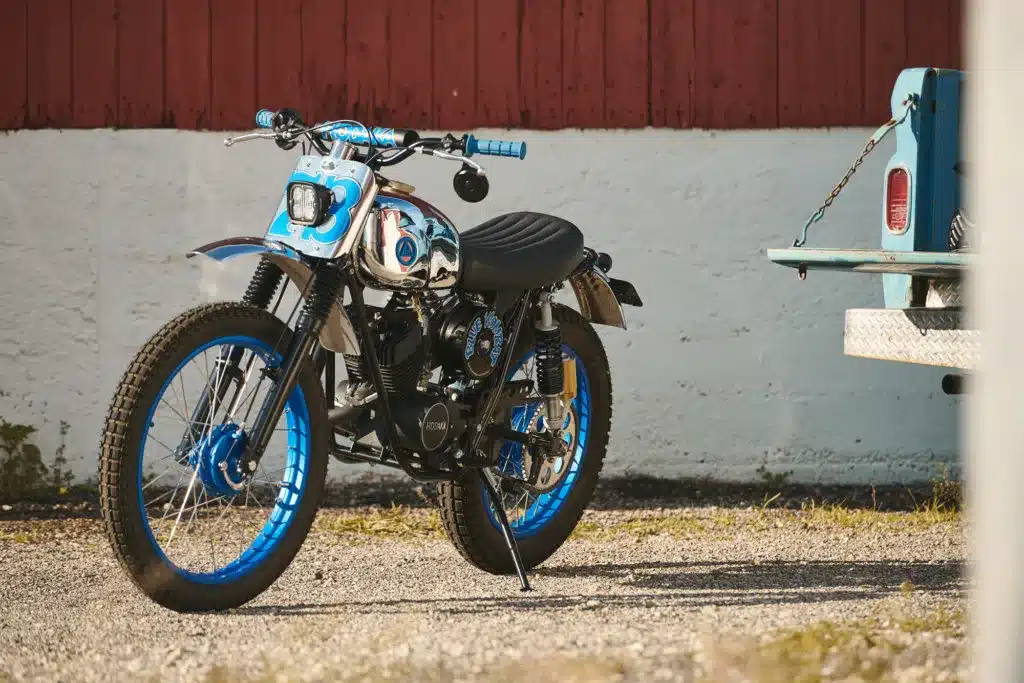 Custom Umbau einer Hodaka Wombat von 1973 mit blauen Akzenten und modernisierter Technik, im Freien stehend.