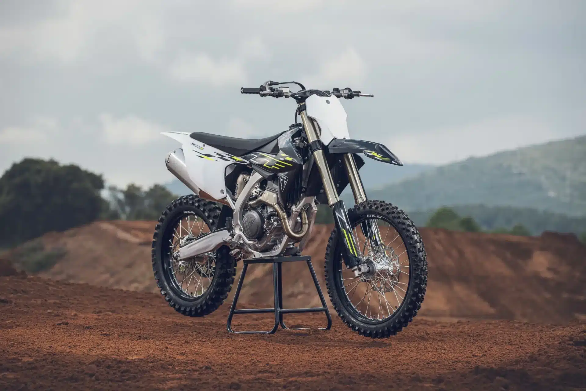 Triumph TF 250-X Motocross-Motorrad Modelljahr 2026 auf einer Offroad-Strecke, Seitenansicht