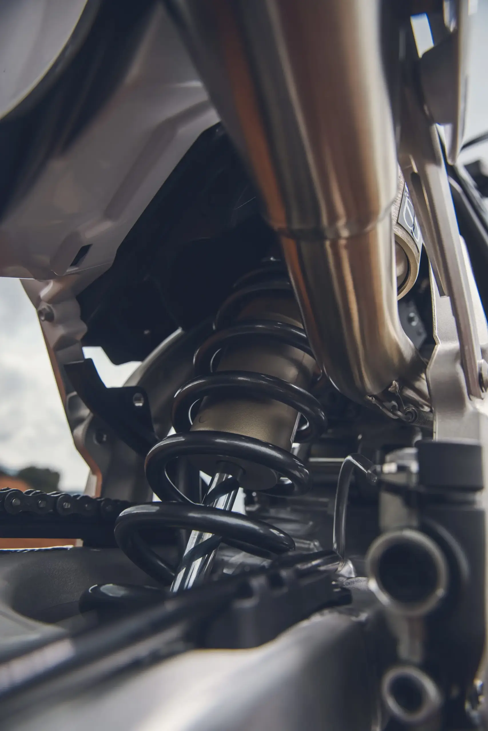 Nahaufnahme des hinteren Federbeins und Fahrwerks der Triumph TF 250-X Motocross-Maschine.