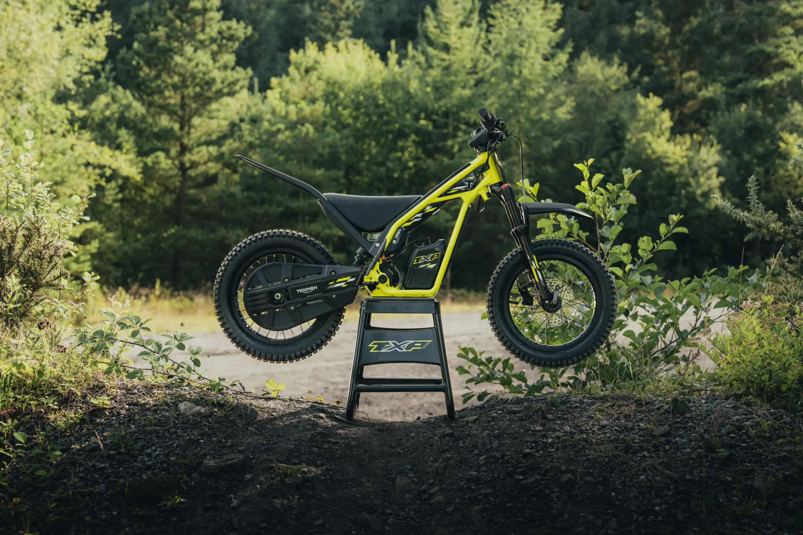 Die Triumph TXP-16 – ein elektrisches Kindermotorrad im Gelände, seitliche Ansicht.