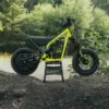 Triumph TXP-12 Elektromotorrad für Kinder im Gelände, Seitenansicht auf einem Erdwall